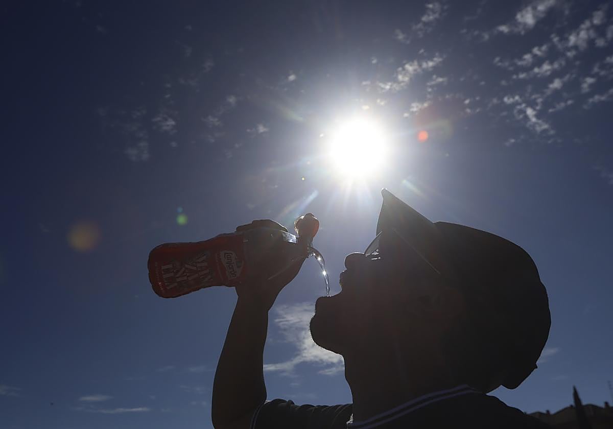 Un hombre se refresca este lunes en Córdoba capital con el sol castigando duramente