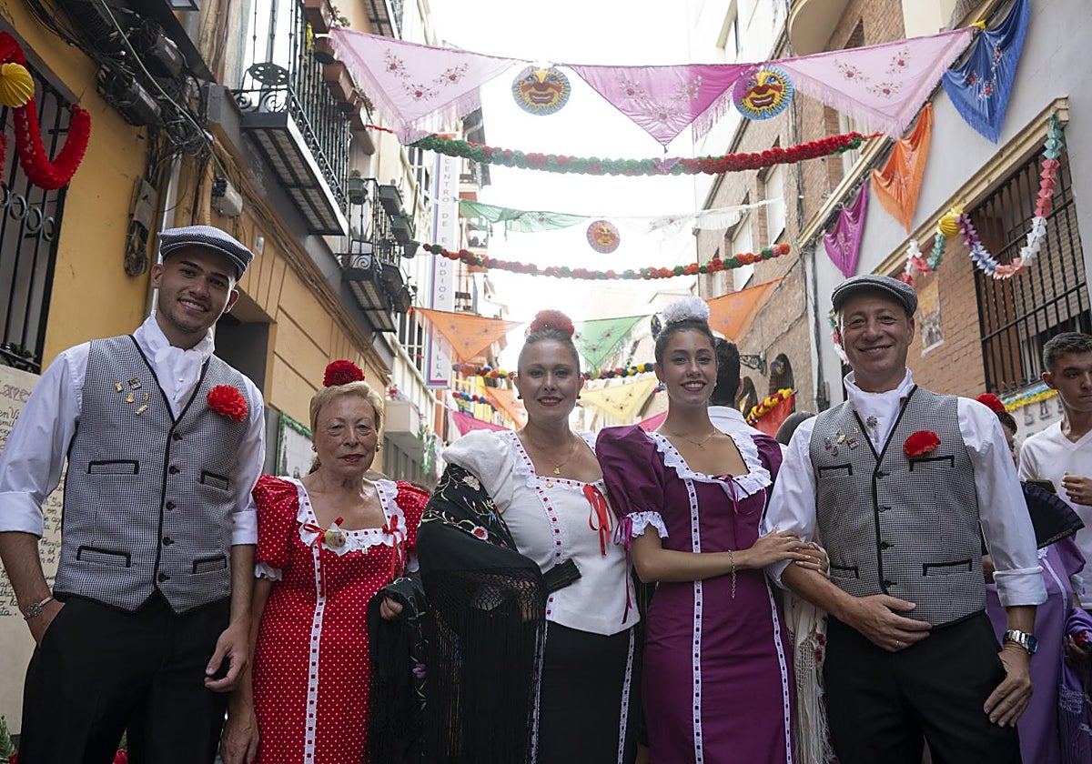 Tres generaciones de la familia que ha decorado la calle del Oso para San Cayetano