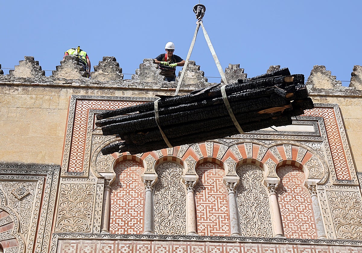 Un operario baja restos materiales del incendio en la Mezquita de Córdoba en las tareas de limpieza