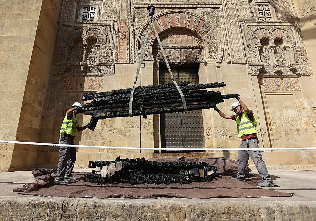 Operarios retirando las vigas quemadas por el incendio