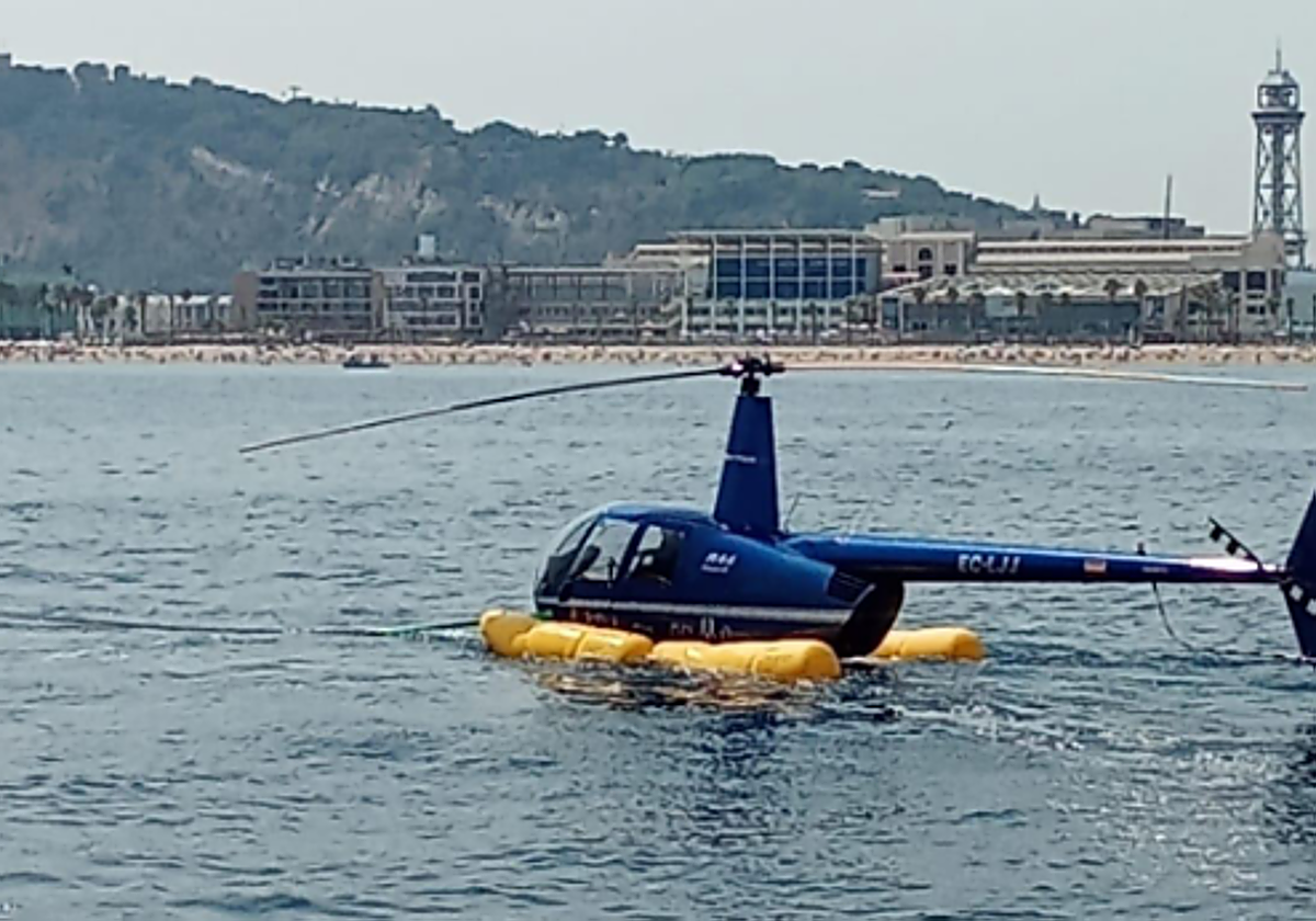 Base de la compañía de helicópteros, en Barcelona, con la nave accidentada, tras ser remolcada y con los flotadores desplegados