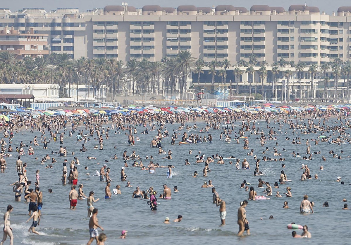 Cientos de personas disfrutan de una jornada de altas temperaturas en la playa de las Arenas (Valencia)