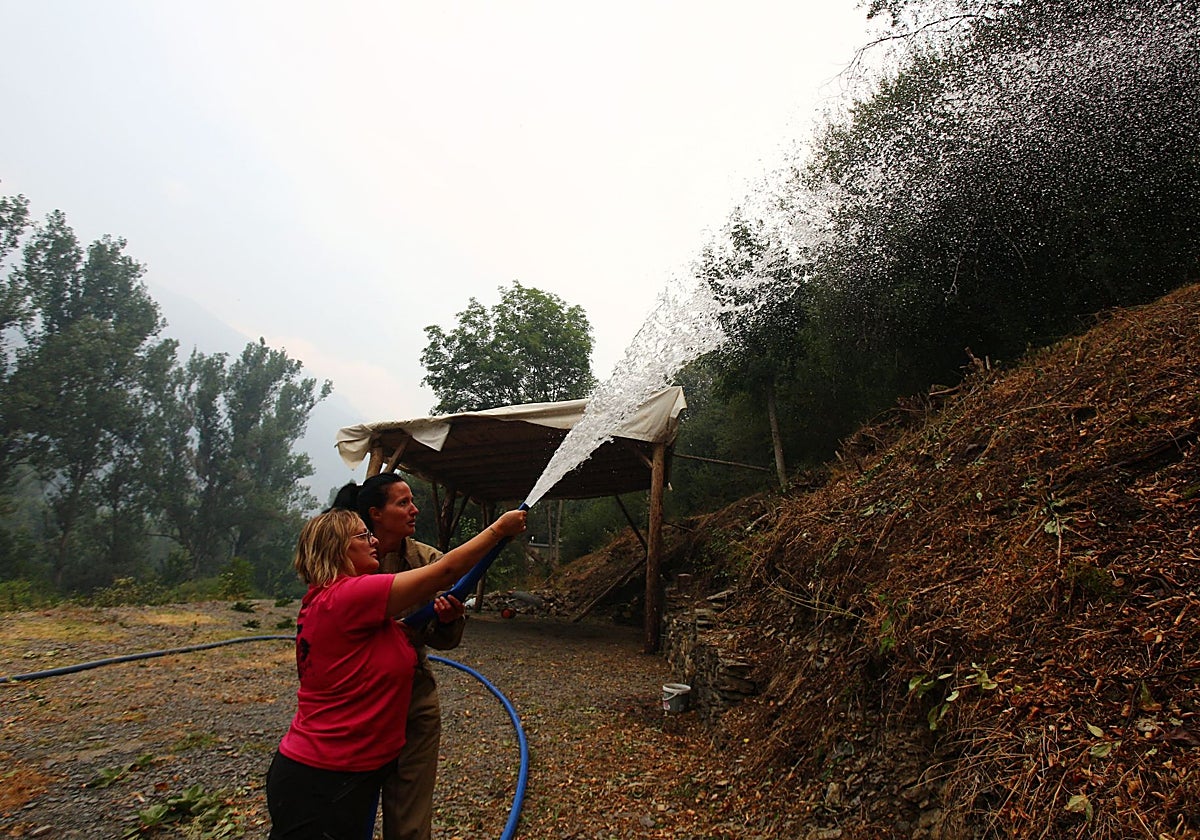Vecinas con una manguera colaboran en la extinción del incendio de Igüeña (León))