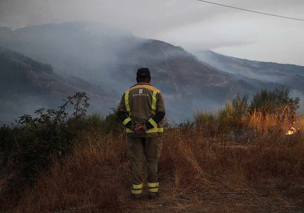 Un bombero forestal observa el paisaje del incendio de A Pobra de Brollón desde Quiroga (Lugo)