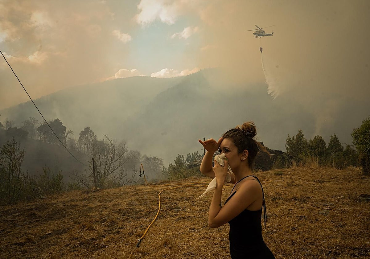 Una vecina observa las columnas de humo de un incendio en Lugo (archivo)
