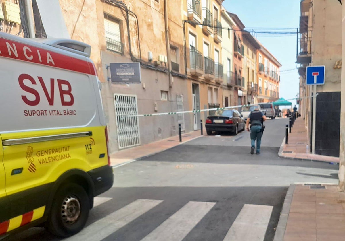 Una ambulancia y un guardia civil, en la calle donde está atrincherado un joven armado desde la madrugada del miércoles en Agost (Alicante)