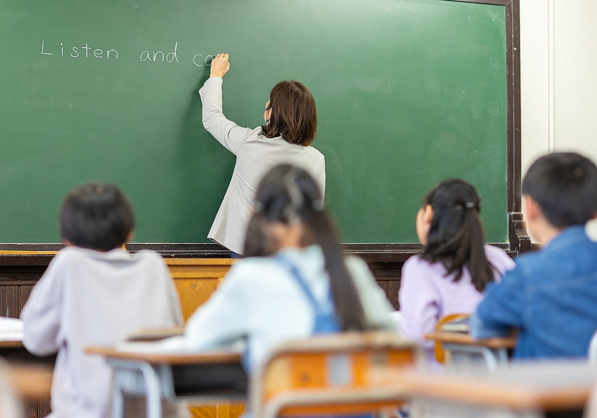 Una profesora de Inglés escribe en la pizarra