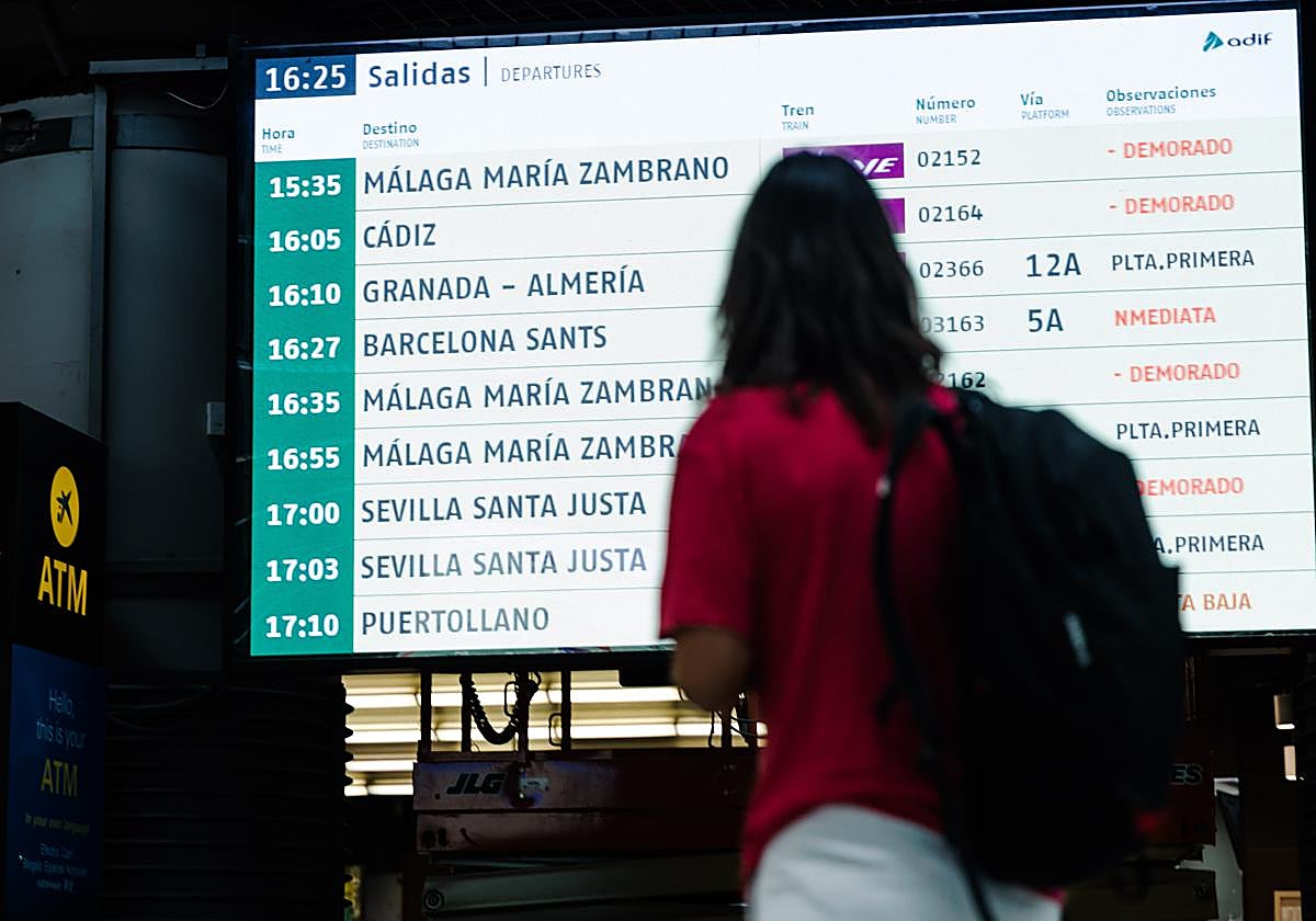 Una persona observa una pantalla informativa en la Estación de Madrid - Puerta de Atocha - Almudena Grandes, a 30 de agosto de 2025, en Madrid (España)