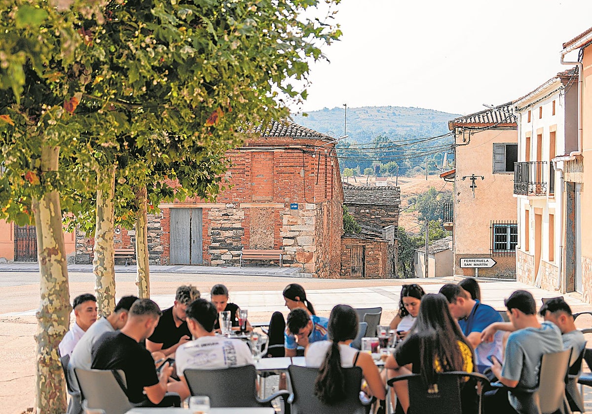 Jóvenes, en la Plaza de Losacio, con el monte quemado al fondo