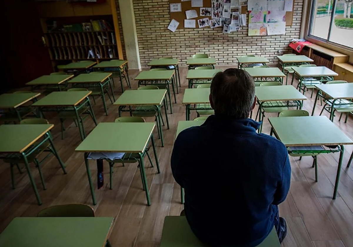 Un profesor en una clase vacía de un colegio
