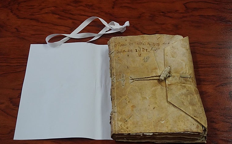 Imagen principal - Arriba, el libro de difuntos. Abajo, izq., detalle de su interior. Dcha, un dibujo de San Cipriano, patrón de Cobeña, también en este voumen