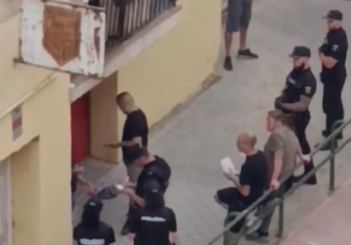 La Policía Nacional, con algunos de los detenidos, a las puertas del local