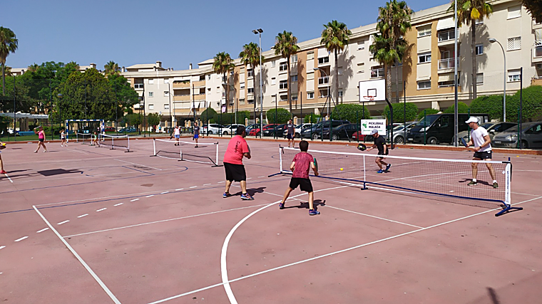 Personas de diferentes edades practicando este deporte en una pista reconvertida