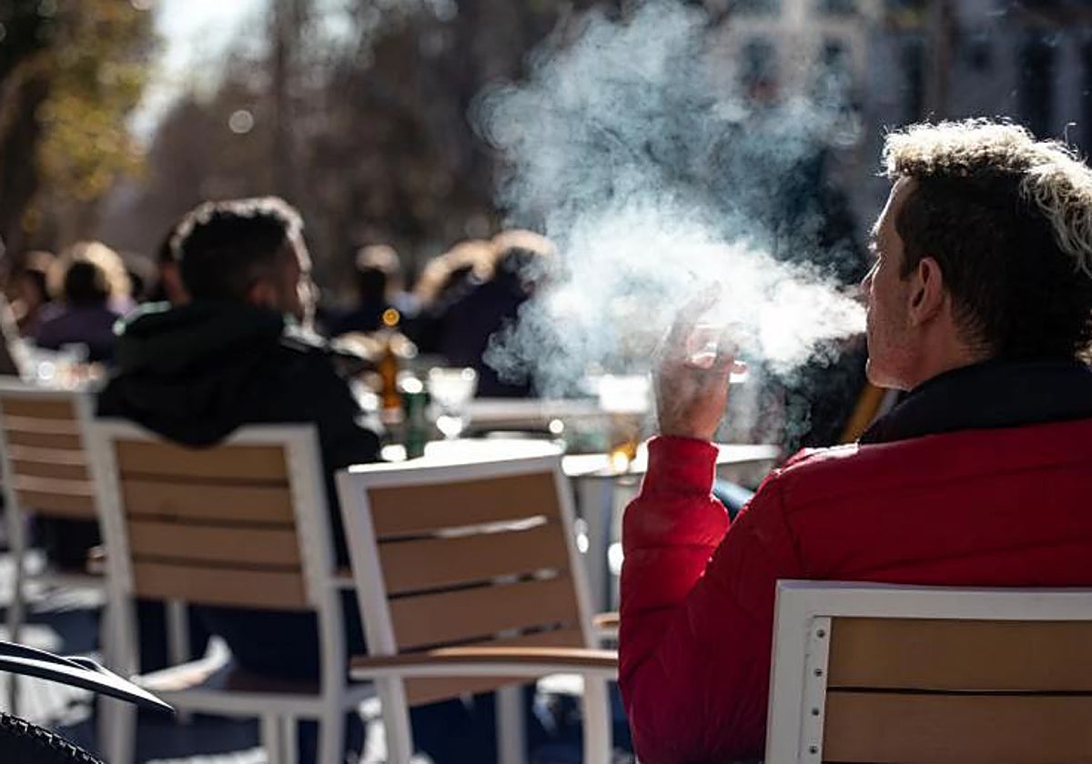 Un hombre fuma en la terraza de un bar