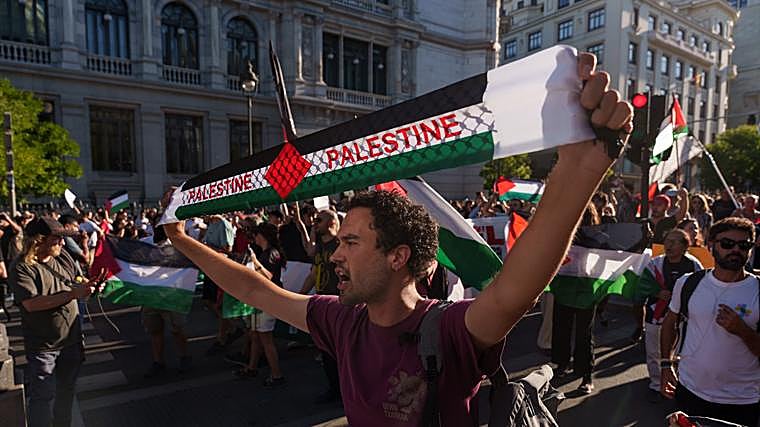 mbre sostiene un pañuelo con los colores de la bandera palestina este domingo en el centro de Madrid.