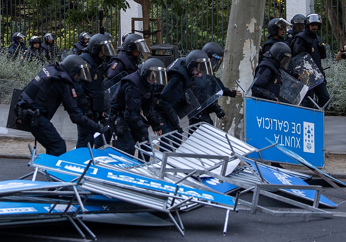 Policías antidisturbios, ayer, entre las vallas lanzadas ayer por los radicales