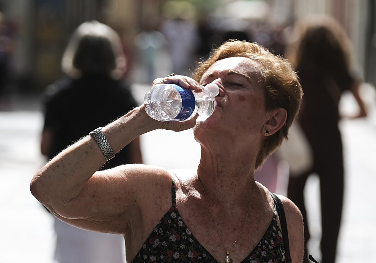 Una mujer bebe agua en un céntrica calle de la capital tinerfeña