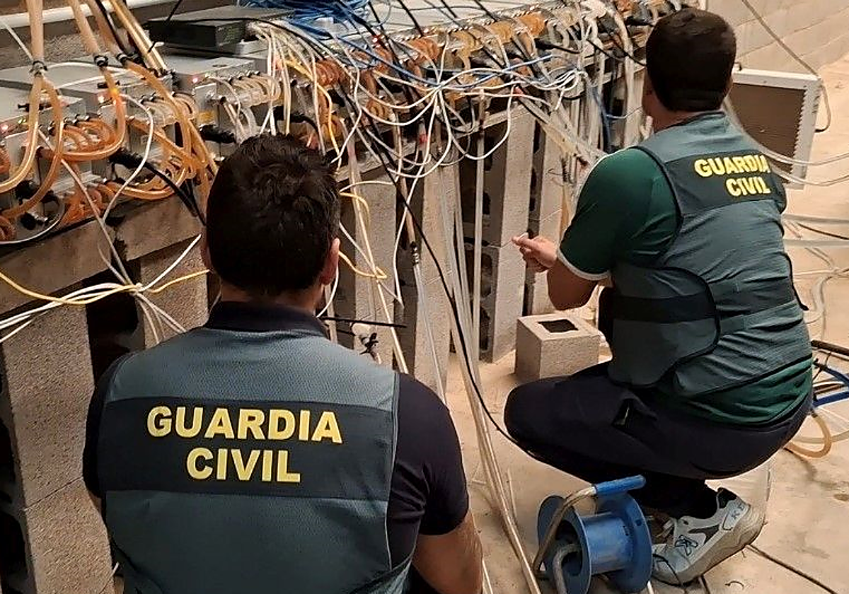 Imagen de dos guardias civiles en la 'granja' de criptomonedas hallada en Castellón