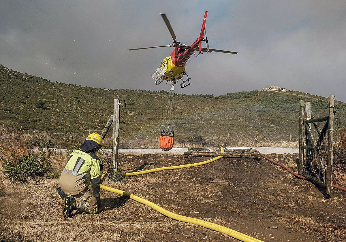 Un helicóptero coge agua en una balsa