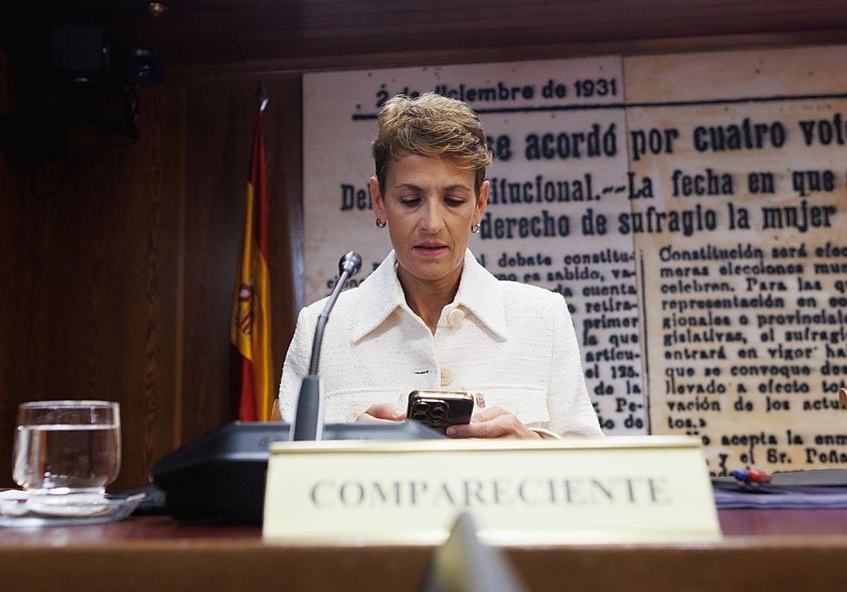 La presidenta de la Comunidad Foral de Navarra, María Chivite, consulta su teléfono móvil durante su comparecencia en la comisión de investigación del Senado por el caso Koldo