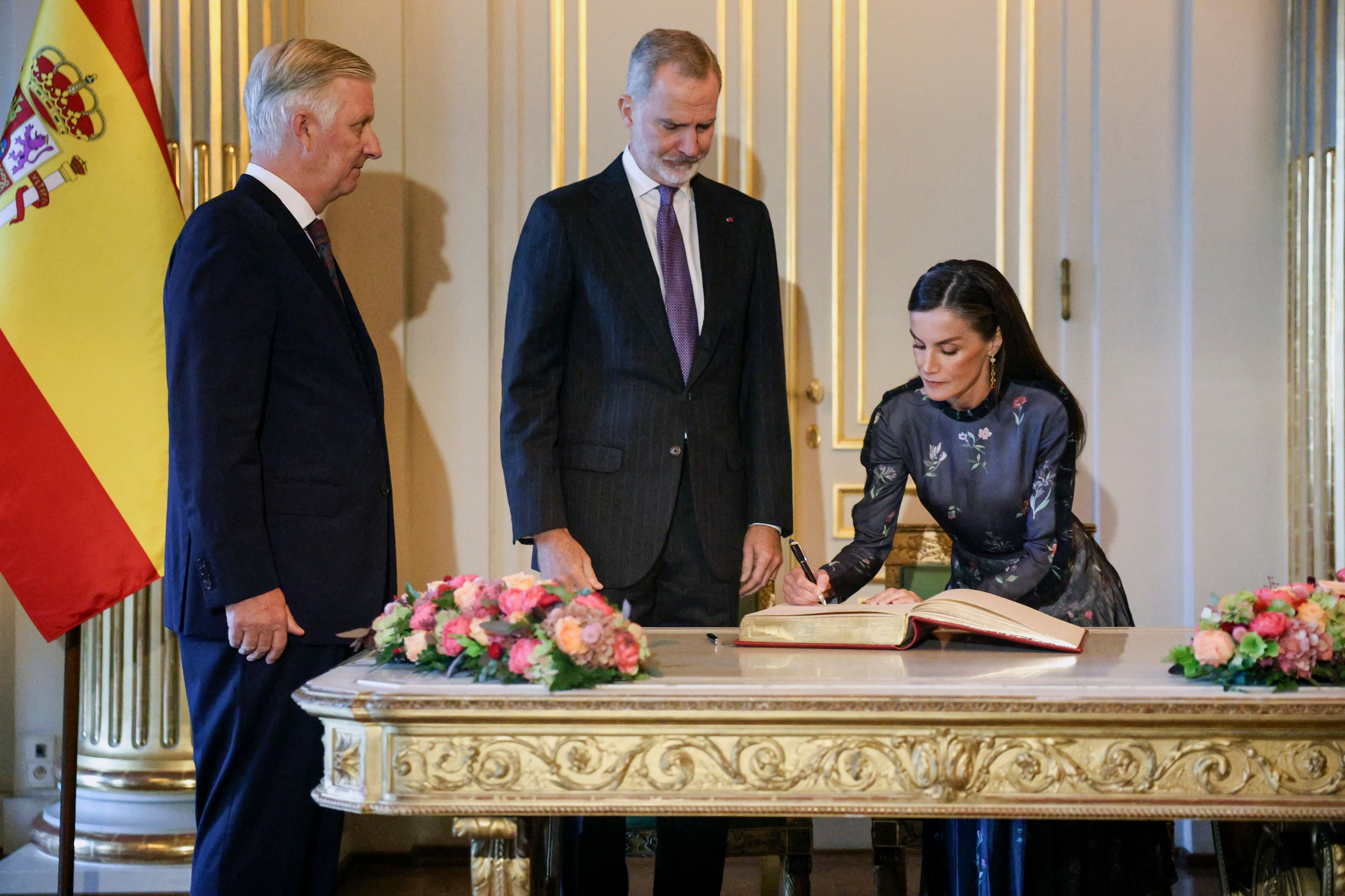 La reina Letizia firma en el libro de visitas junto a Felipe vI y el rey Felipe de Bélgica en el Palacio Real de Bruselas