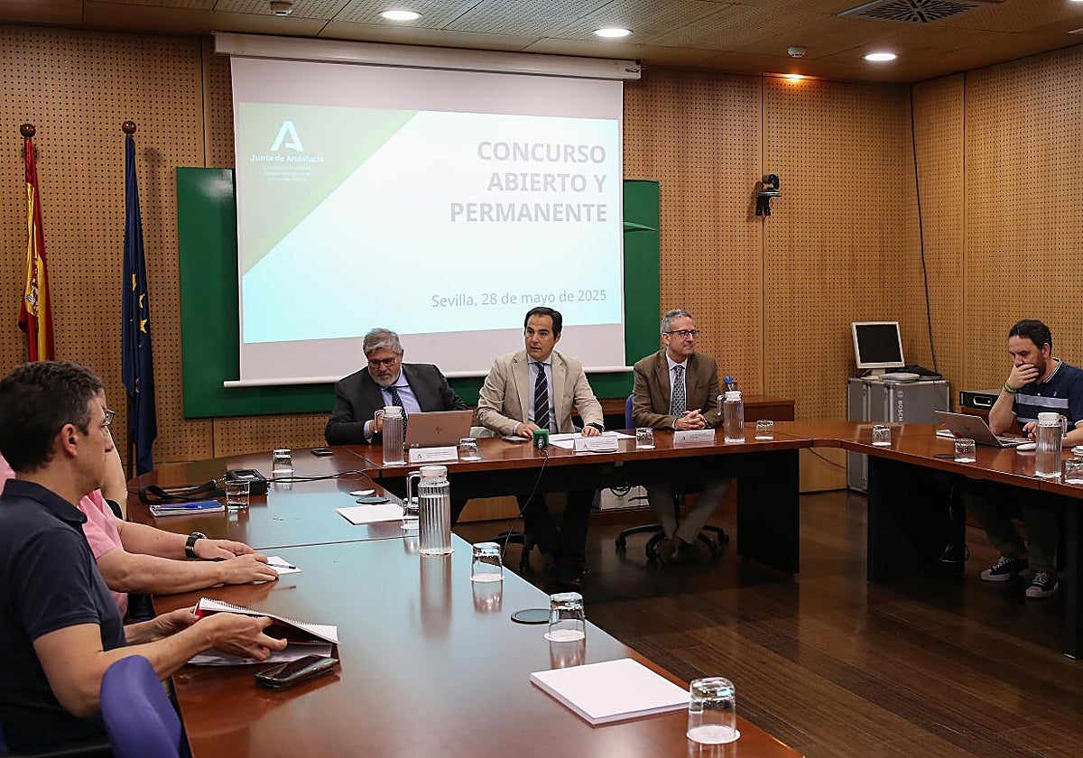 El consejero José Antonio Nieto (centro), en una reunión sobre el concurso abierto y permanente en la Junta de Andalucía en mayo de 2025