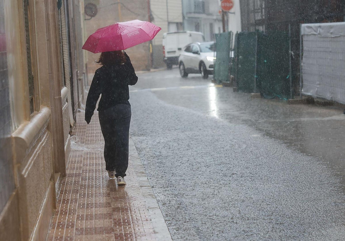 Una persona se protege de la lluvia con un paraguas en Valencia