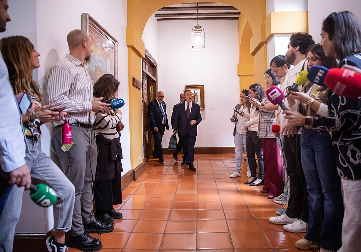 Pasillo flanqueado por los medios de comunicación mientras Page avanza hacia el salón de Plenos