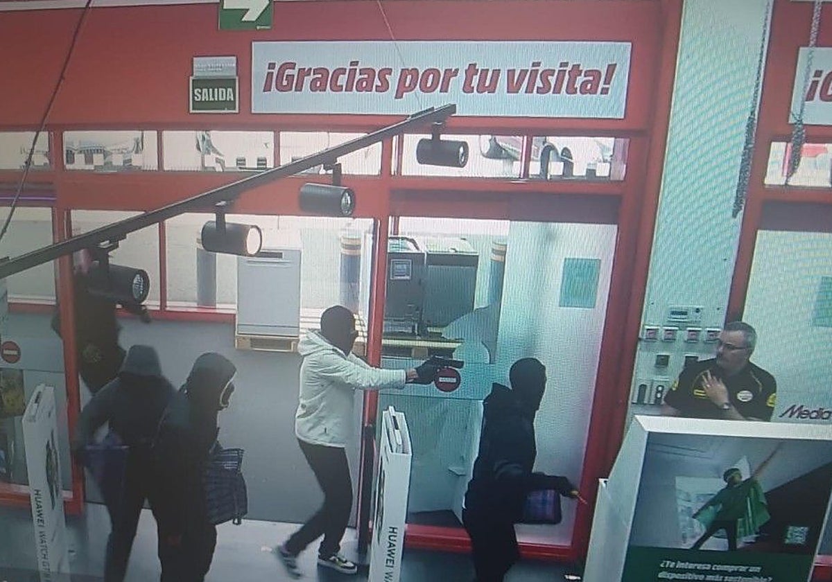 Momento en el que los cinco atracadores entran en la tienda y encañonan al vigilante