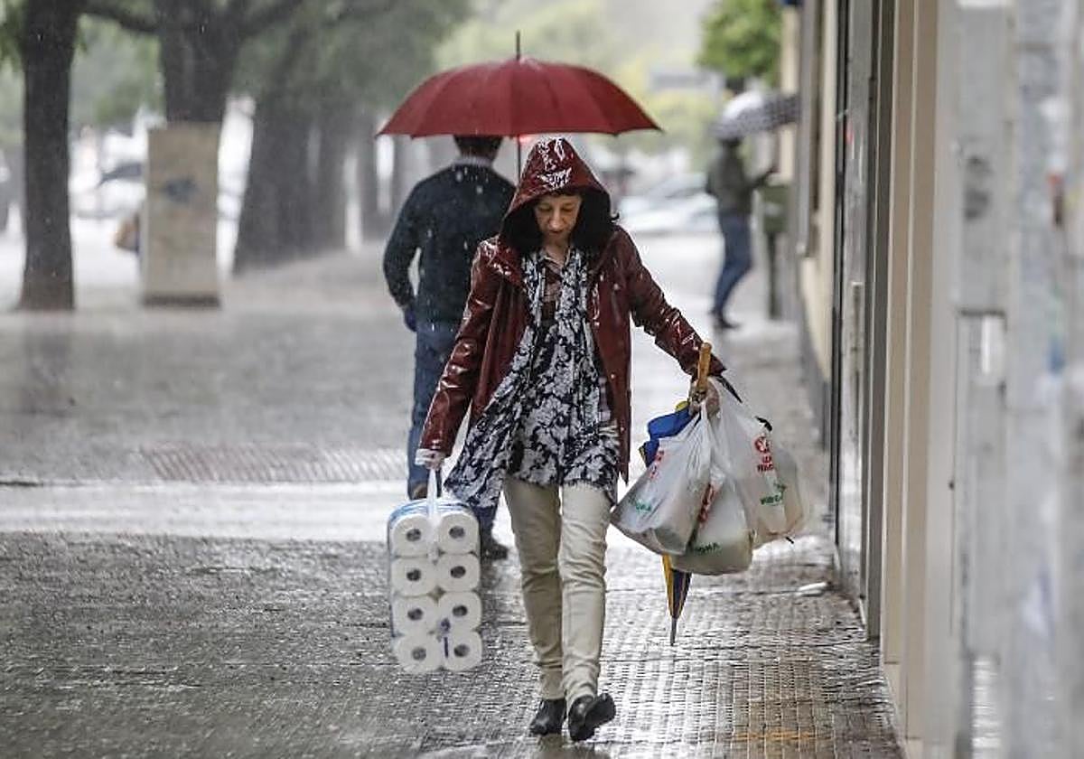 Una mujer con chubasquero caminando por la ciudad