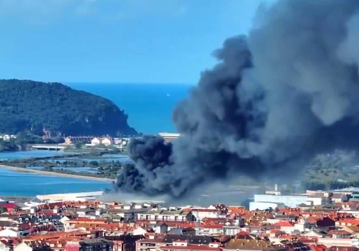 Gran columna de humo procedente sale de la conservera tras incendiarse.