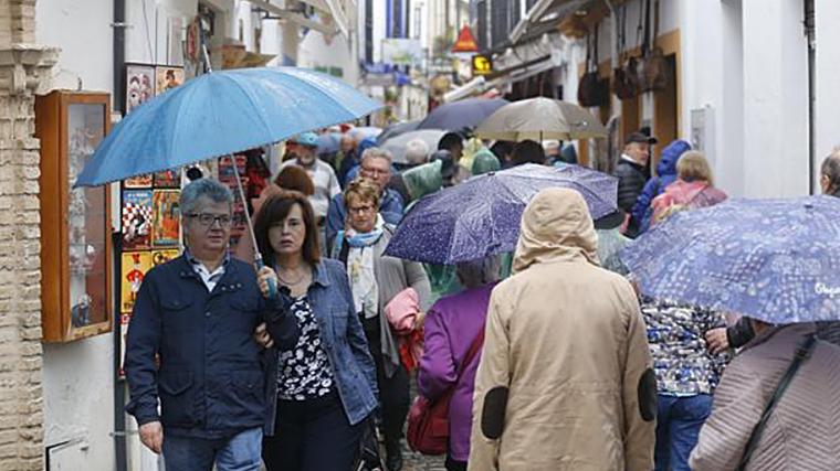Gente paseando por el centro de Córdoba un día de octubre con ambiente fresco y lluvia