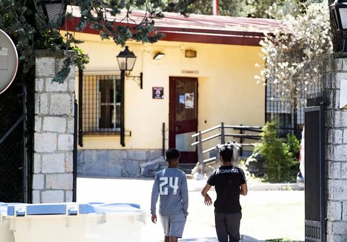 Dos menores migrantes no acompañados a la entrada de un centro en foto de archivo