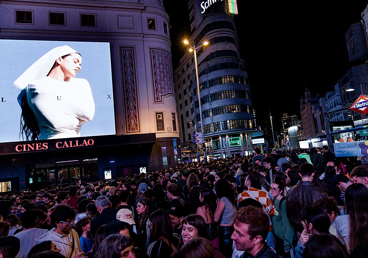 Decenas de personas observan la portada del nuevo álbum de Rosalía, 'Lux', en la madrileña plaza de Callao, hace unos días