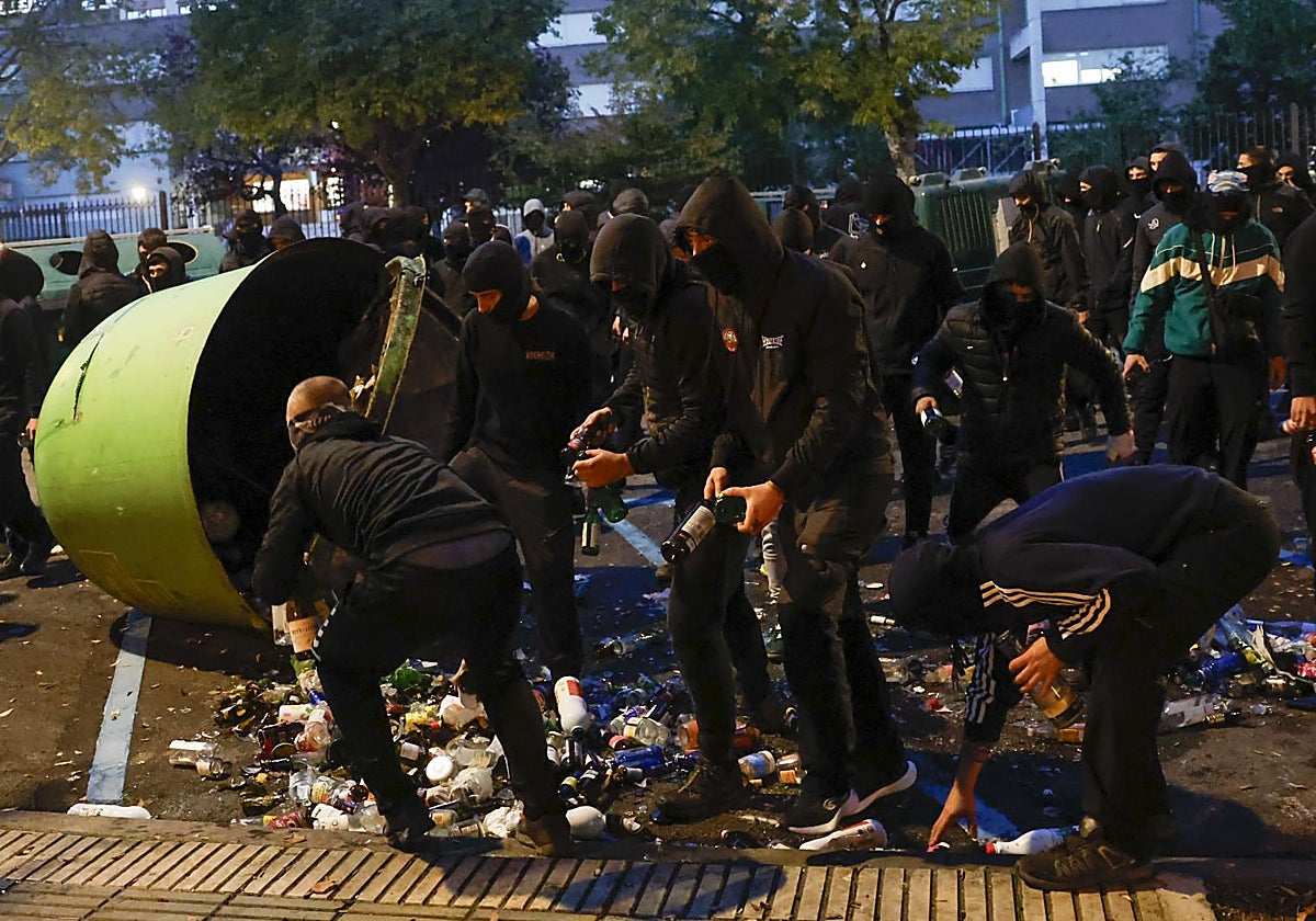 Un grupo de embozados recoge vidrio para lanzarlo sobre la Policía Nacional este jueves en Pamplona