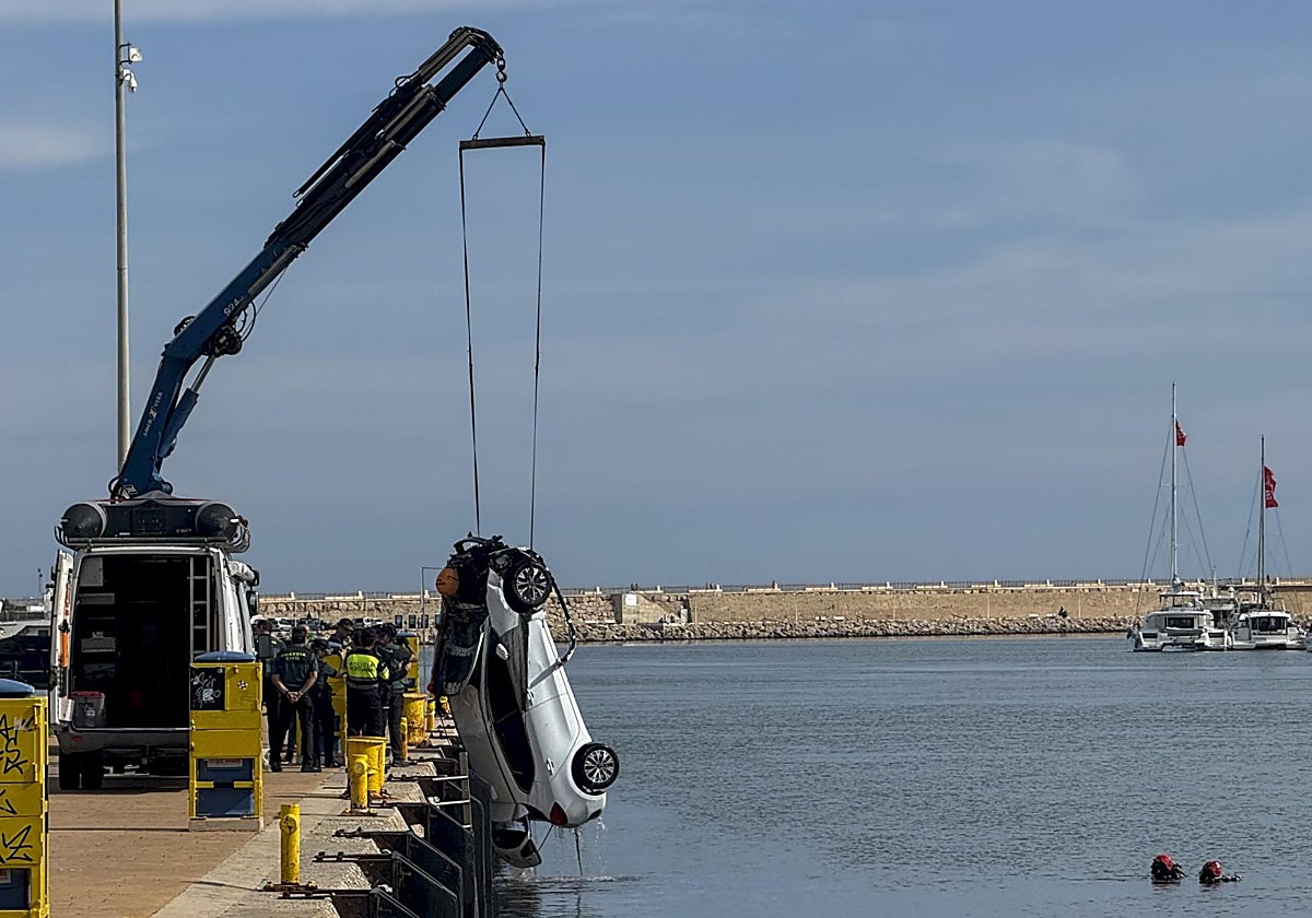 Una grúa saca el coche del accidente mortal del agua en el puerto de Gandía