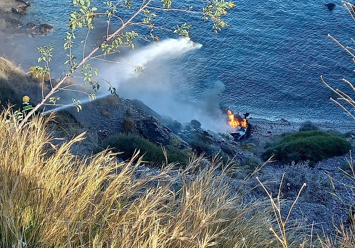Imagen de una patera neumática ardiendo tras su llegada a la costa