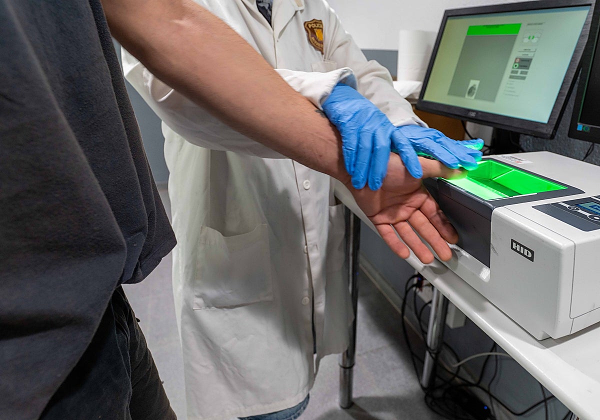 Un agente toma las huellas a un detenido, en una imagen de archivo