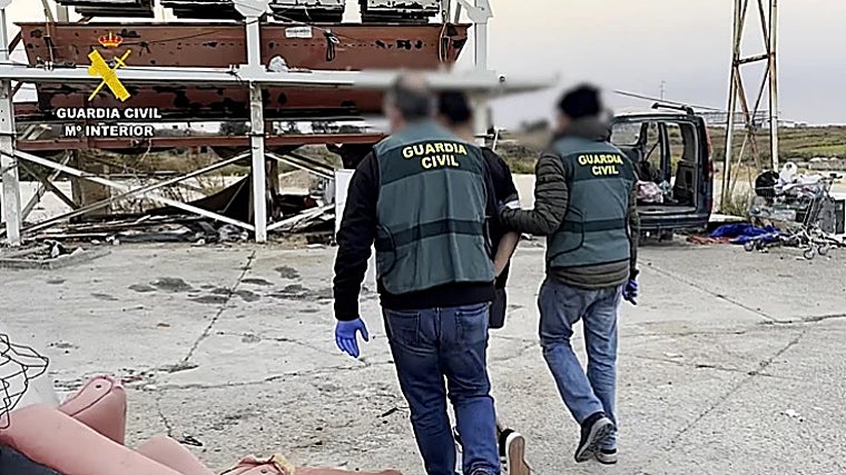 Dos agentes con uno de los detenidos