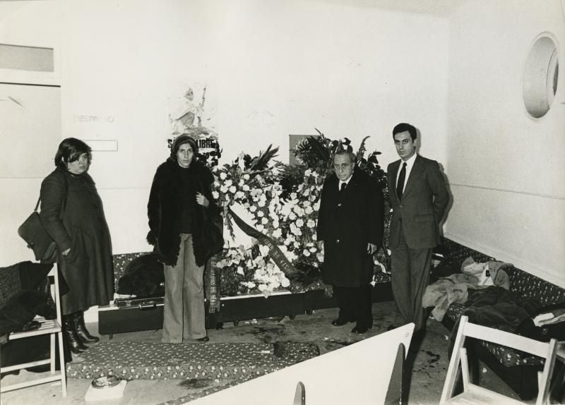 En la imagen, de izquierda a derecha, Cristina Almeida, Manuela Carmena, titular del despacho de Atocha, el señor Pedrol y el secretario del Colegio de Abogados, Gonzalo Casado. Una corona de flores recuerda el lugar donde tuvo lugar el asesinato