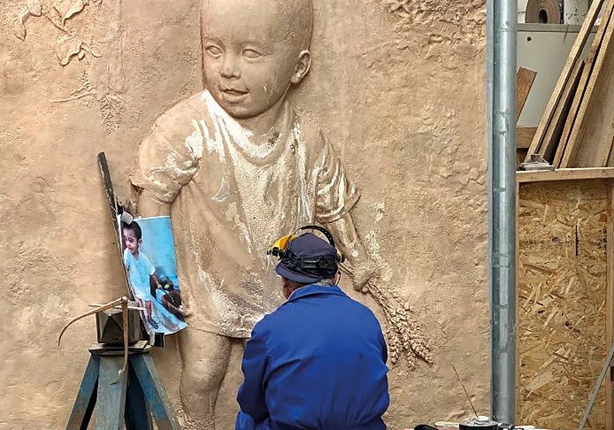 El artista, trabajando en la puerta dedicada al Niño Jesús