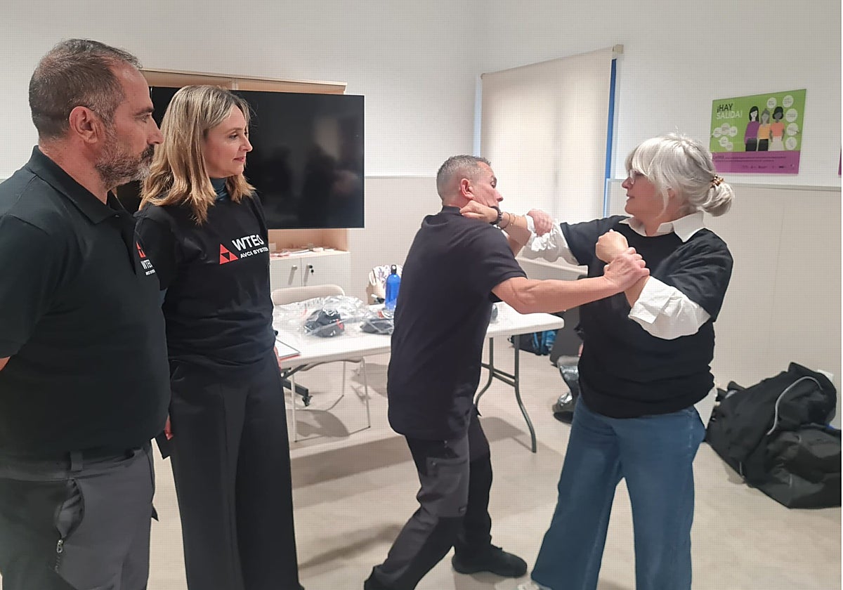 Un monitor enseña técnicas de defensa personal a una mujer