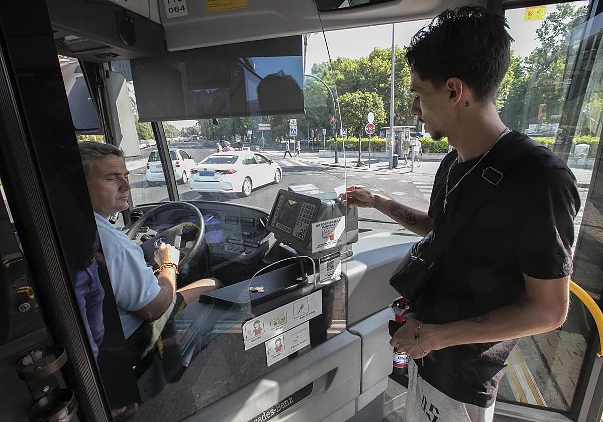 Un usuario paga su billete en un autobús de Aucorsa
