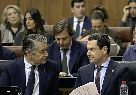 El presidente andaluz, Juanma Moreno, habla con el consejero de Sanidad, Antonio Sanz, este jueves en el Pleno del Parlamento andaluz