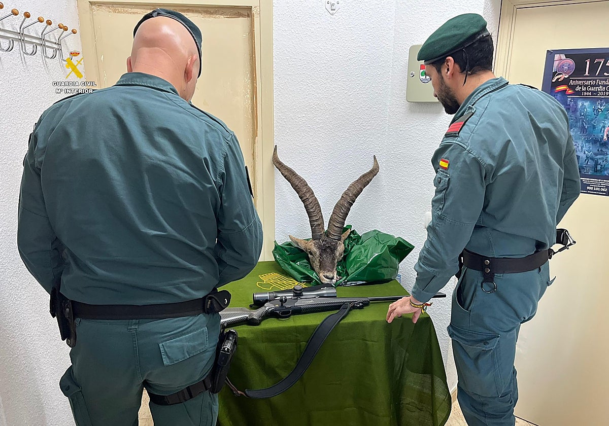 Imagen de dos agentes de la Guardia Civil con el rifle y la cabeza del animal