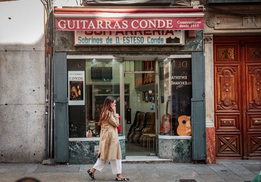 Una mujer para por delante de un comercio centenario en el centro de Madrid.