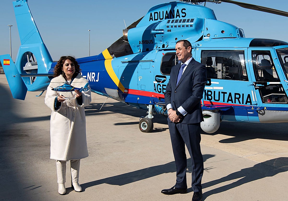 Montero frente a un helicóptero de la Agencia Tributaria con una réplica en las manos.