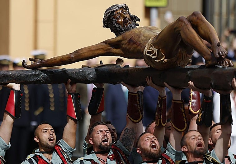 Los legionarios trasladan al Cristo de la Buena Muerte por las calles de Málaga.