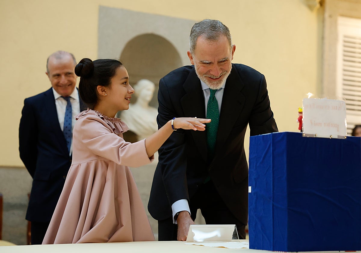 El Rey Felipe VI junto a una niña este lunes durante el concurso '¿Qué es un Rey para ti?