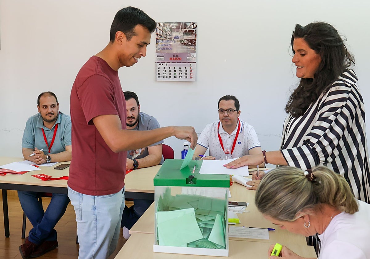 Un hombre vota en Adamuz; detrás, de verde, el alcalde, el socialista Rafael Ángel Moreno
